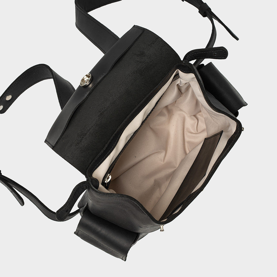 Czarny skórzany plecak damski otwarty, ukazujący beżowe wnętrze z przegrodami, TAKSUBA