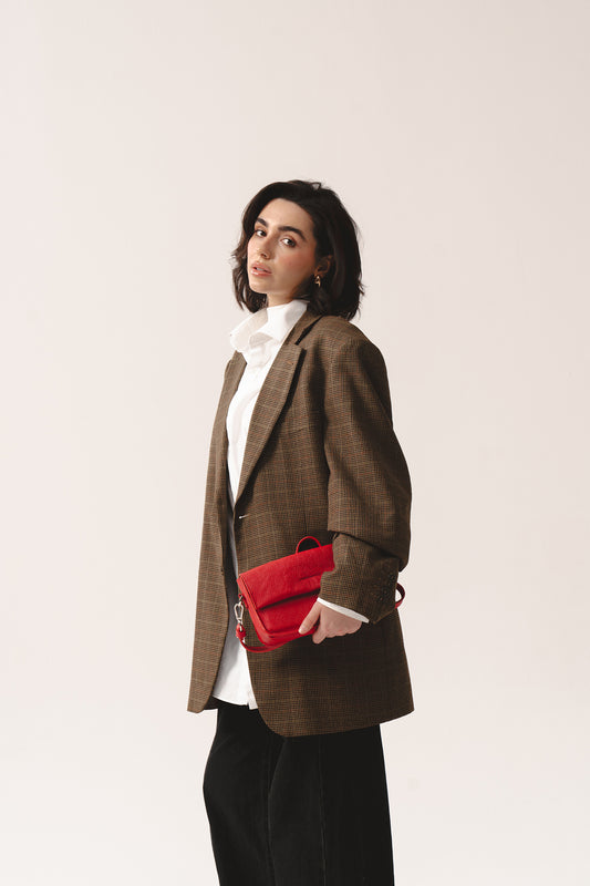 Czerwona minimalistyczna skórzana torebka typu crossbody w stylizacji casualowej – red leather crossbody purse in hand, compact shoulder style