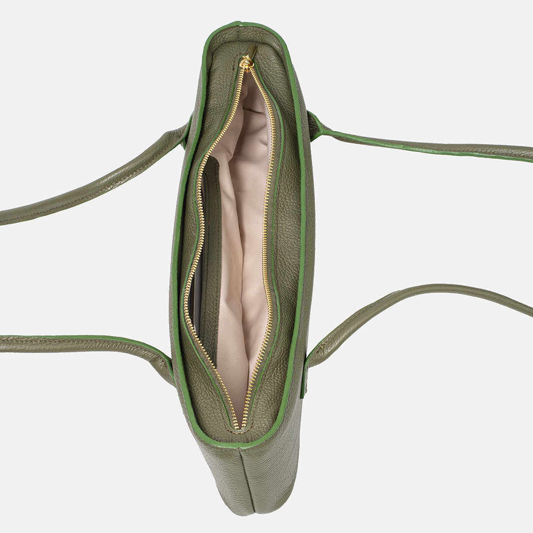 Górny widok otwartej zielonej skórzanej torebki z beżowym wnętrzem i złotymi zamkami