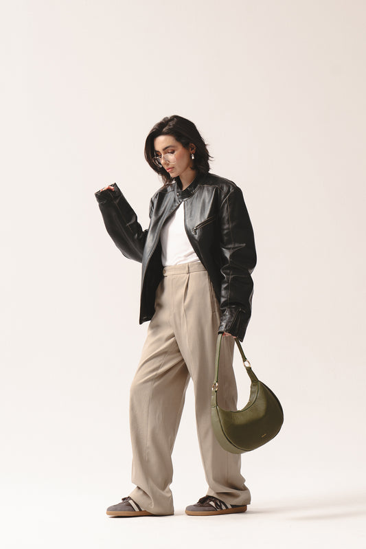 Skórzana torebka na ramię Hedera w oliwkowej zieleni – olive green crescent leather handbag styled with beige trousers and black jacket