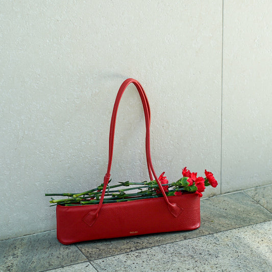 Czerwona skórzana torebka Lamina stylizowana z kwiatami na tle miejskim