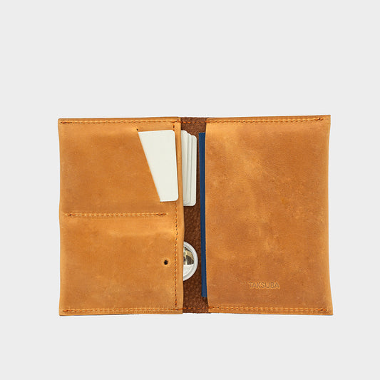 Skórzane etui na paszport z AirTag w kolorze pomarańczowym, z kieszeniami na karty i ukrytą kieszenią na AirTag.