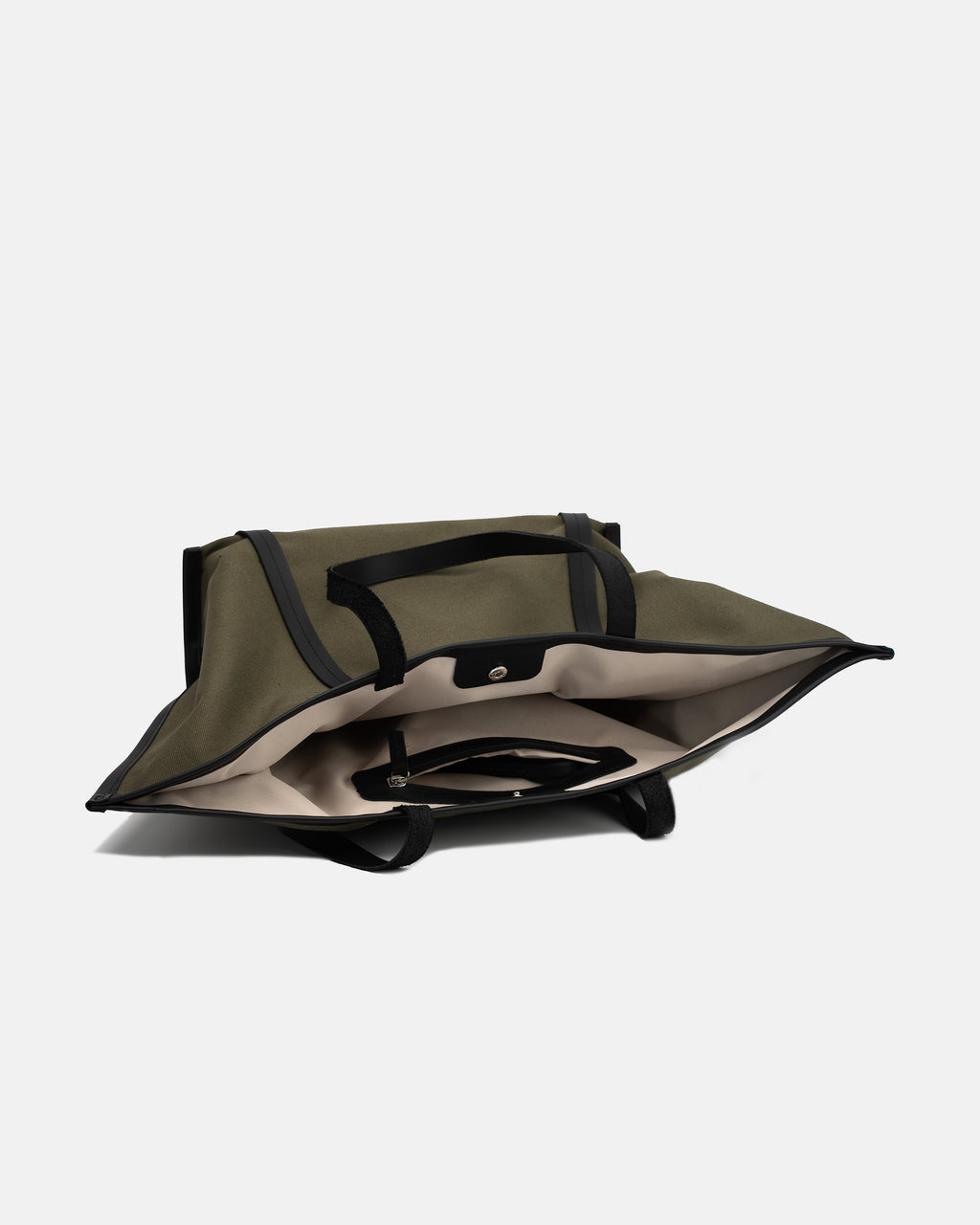 Open interior view of Astra Shopper Canvas olive tote bag showing the main compartment, slip pocket, and zippered pocket