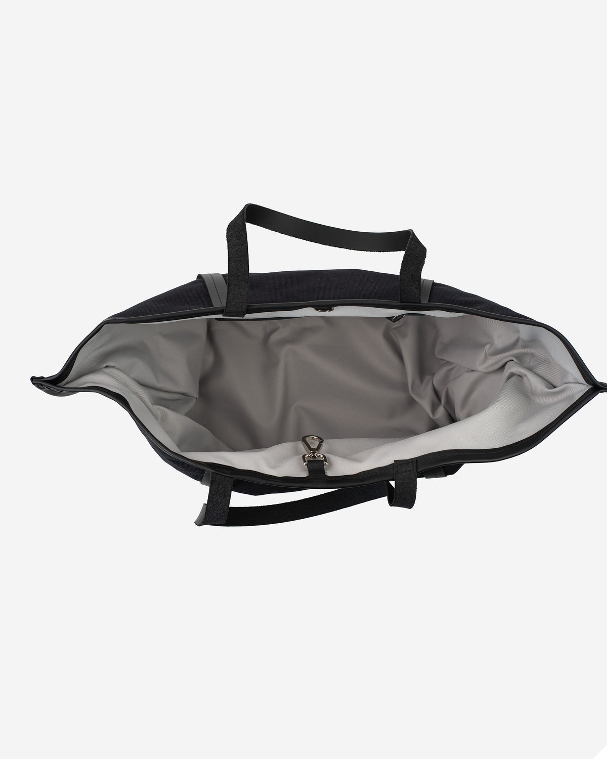 Black canvas tote bag with black handles, open top view showing the spacious gray interior and metal clasp closure.