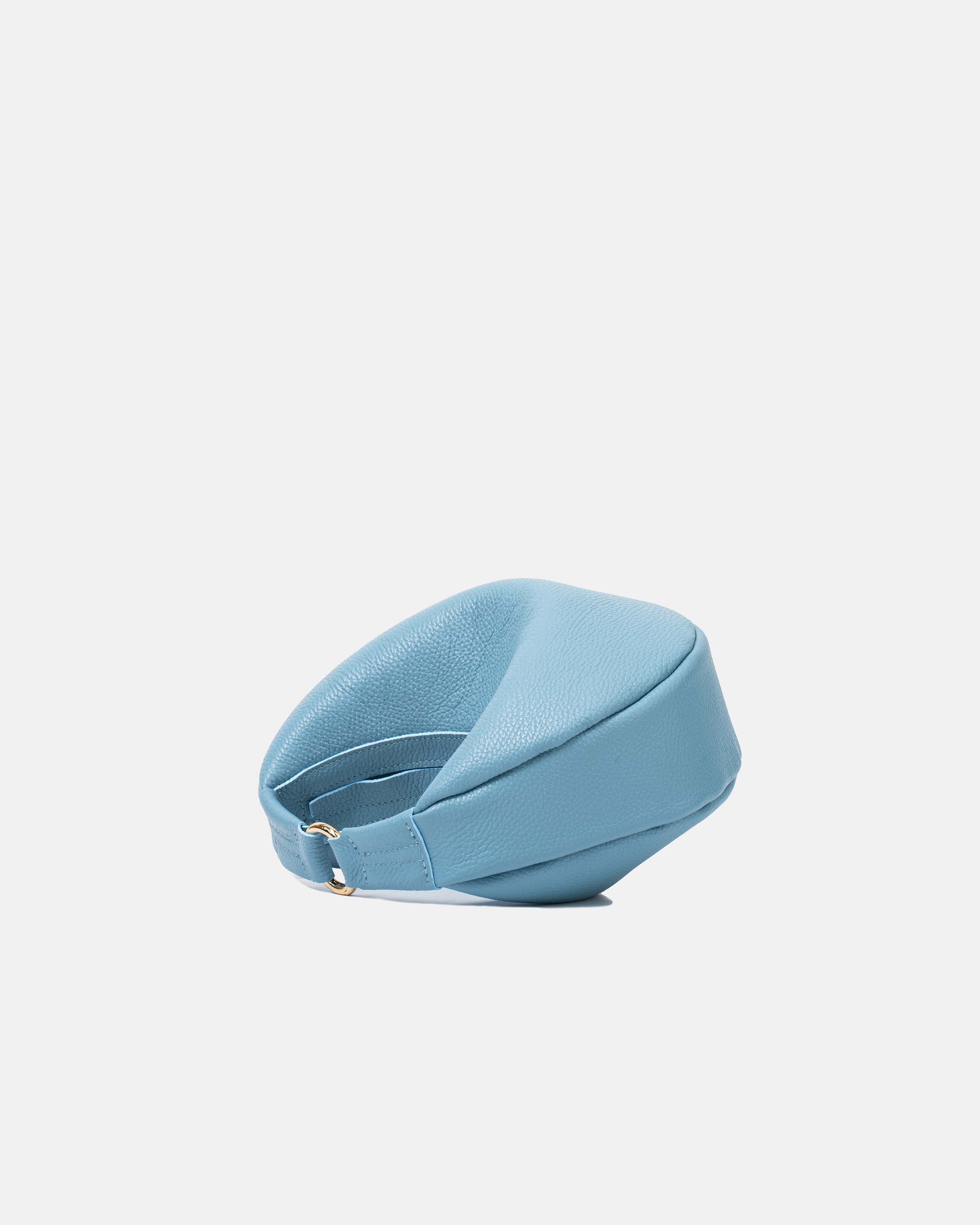 Boczny widok niebieskiej skórzanej torebki damskiej w kształcie półksiężyca z delikatnymi złotymi akcentami.