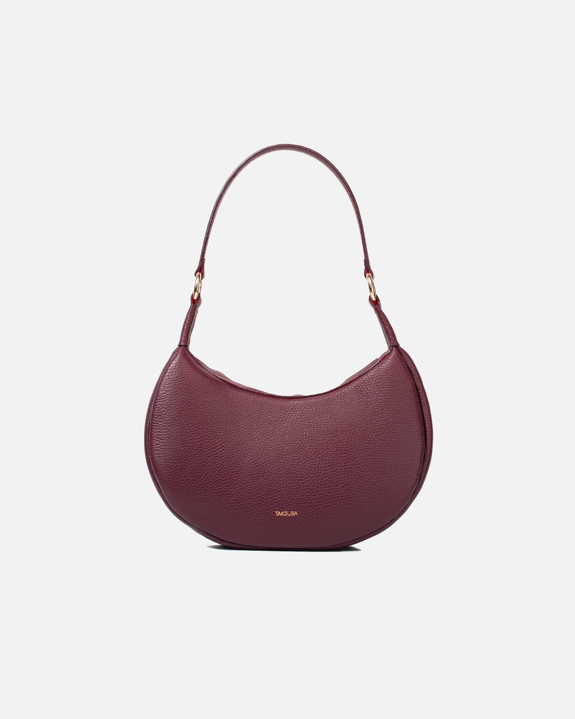  Bordowa skórzana torebka damska o półokrągłym kształcie z złotymi elementami i regulowanym paskiem.