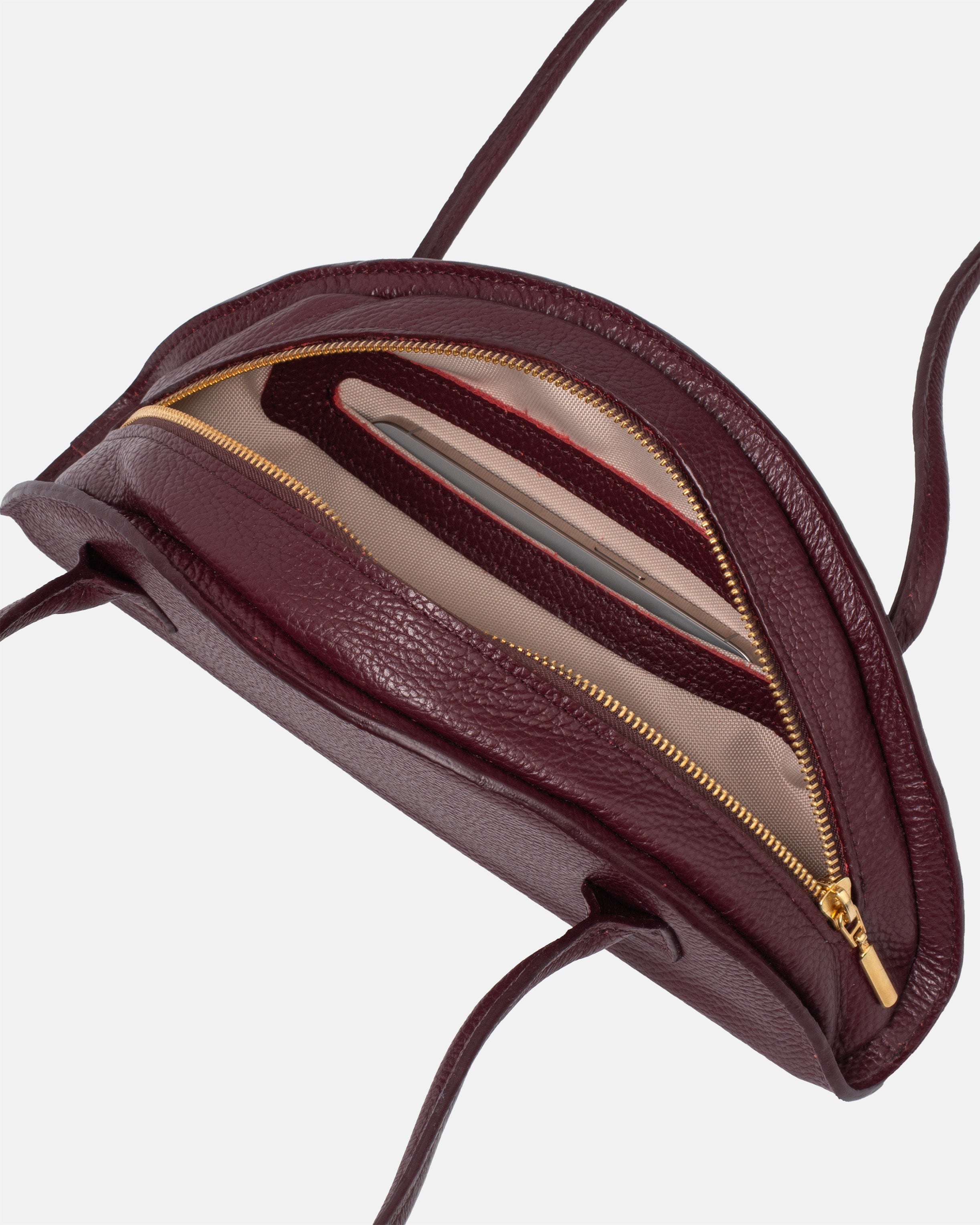 Wnętrze bordowej torby skórzanej damskiej marki Taksuba z widoczną złotą kieszenią na zamek, beżową podszewką i przegrodami na karty.