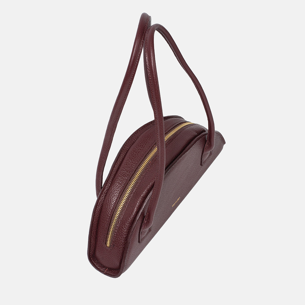 Bordowa torba skórzana damska marki Taksuba z fakturowanej skóry, ze złotym zamkiem i dwoma długimi uchwytami na ramię.