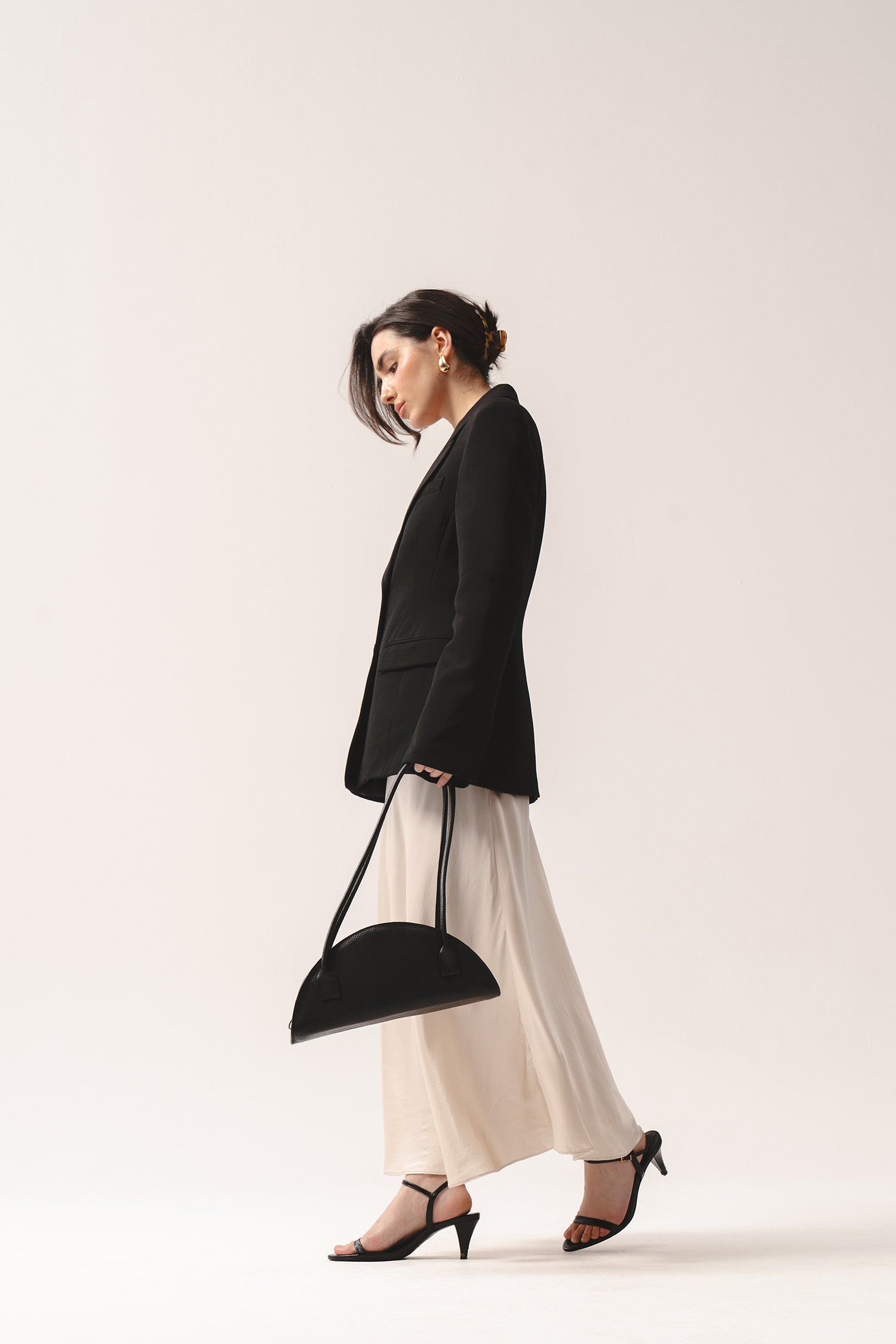 Elegancka czarna torebka Amber półokrągła skórzana na długich rączkach w minimalistycznej stylizacji

