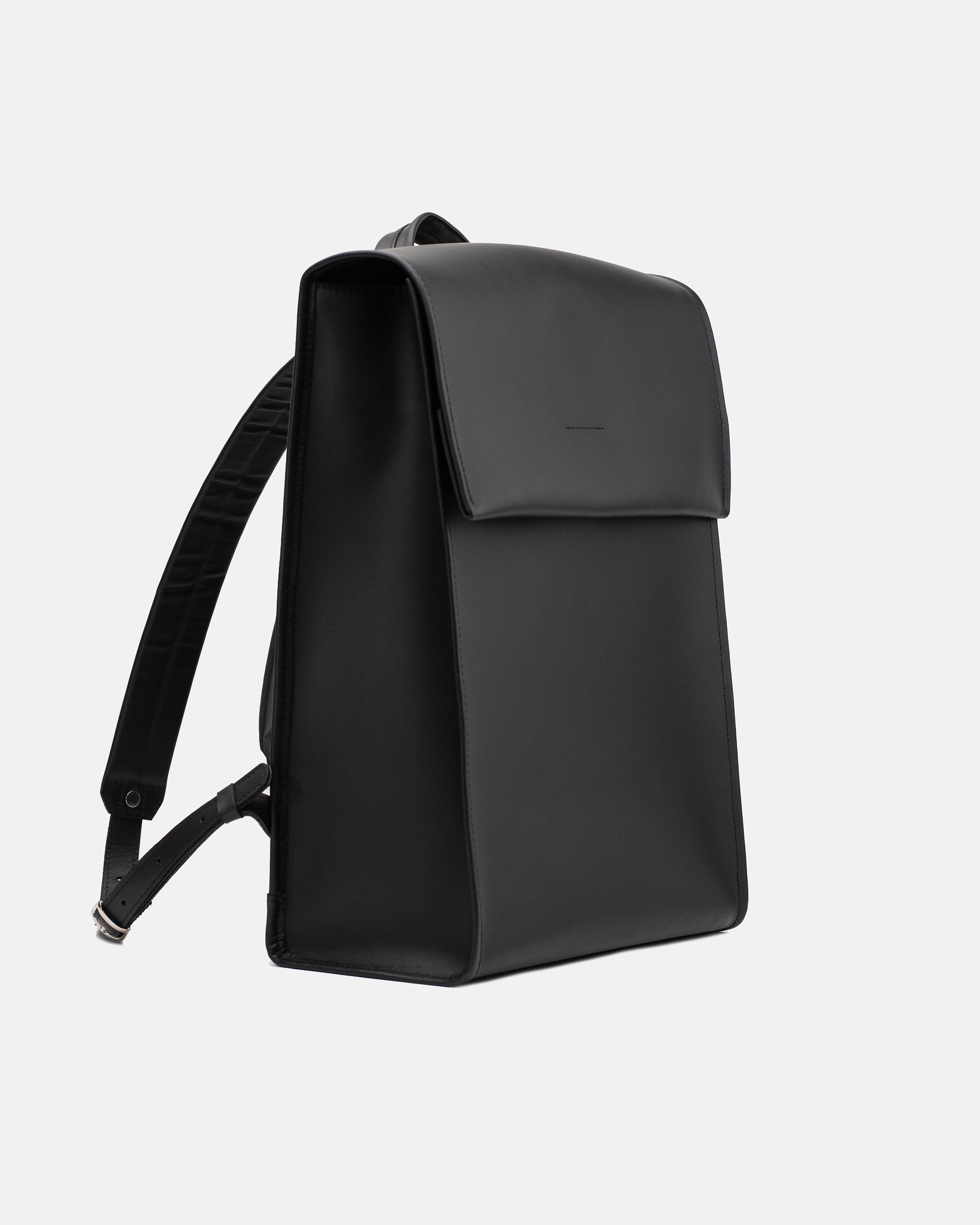 Angled front view of the large black leather backpack with smooth finish and adjustable strap