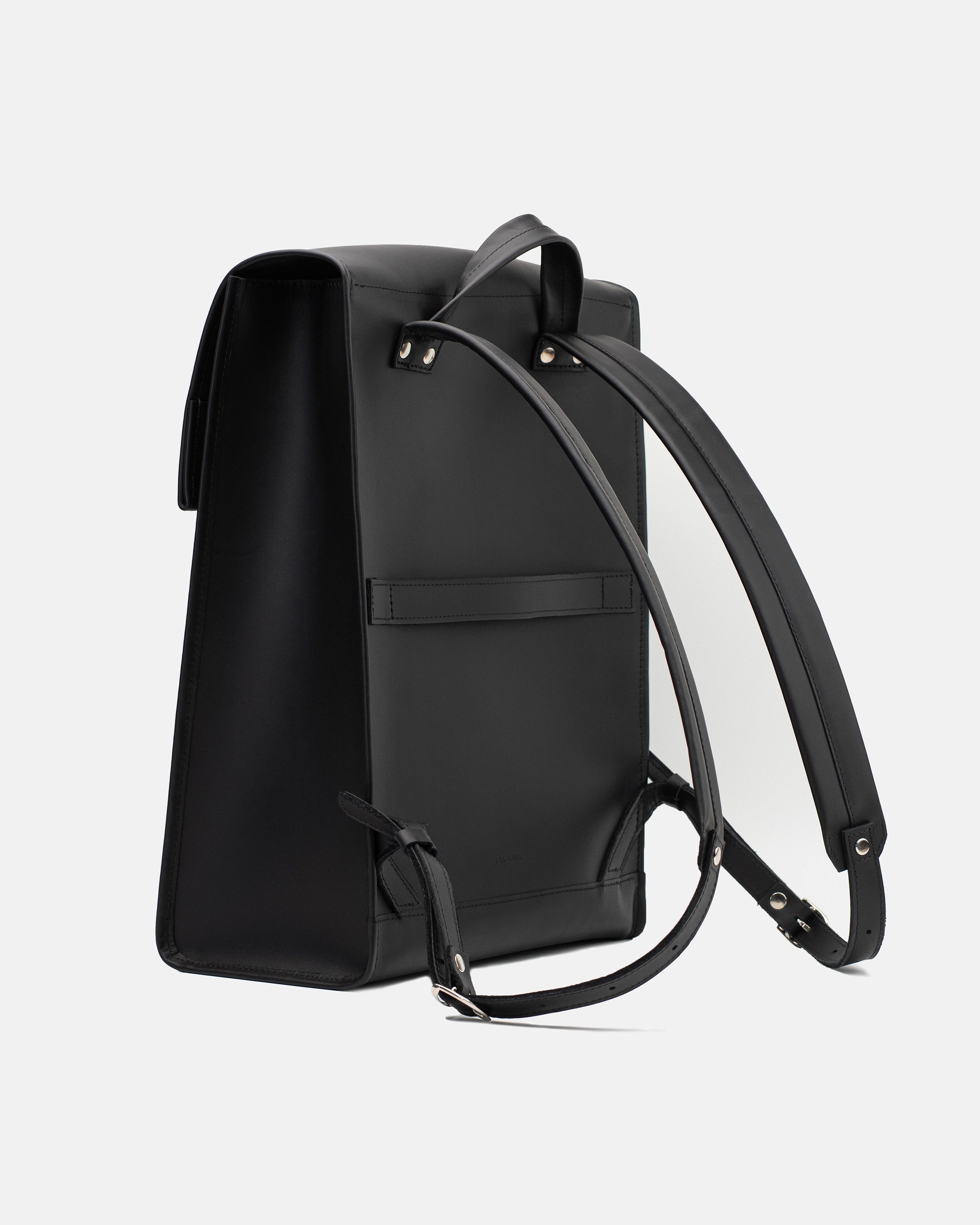 Rear view of the large black leather backpack with shoulder straps and horizontal luggage strap