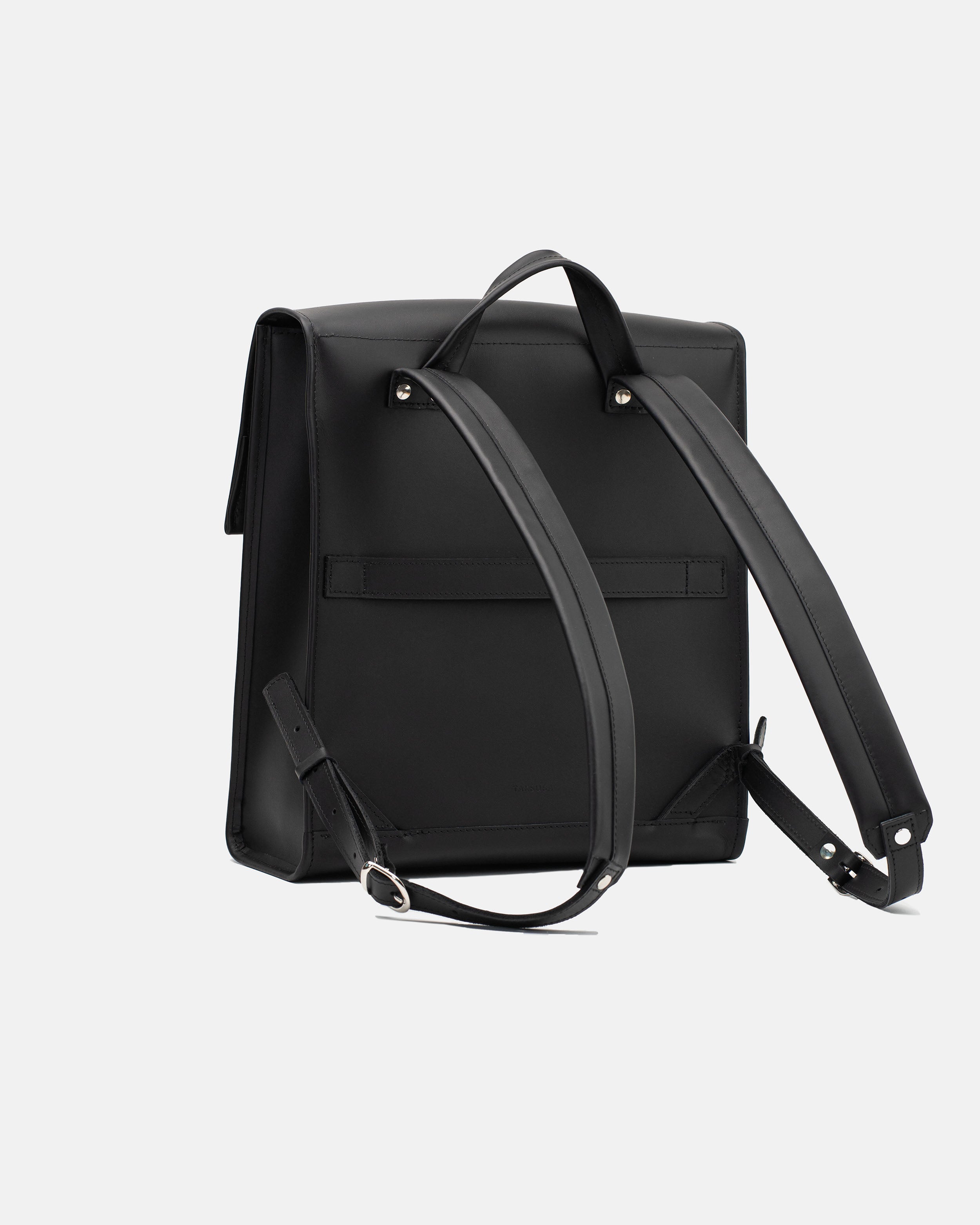 Rear view of the medium black leather backpack with shoulder straps and horizontal luggage strap
