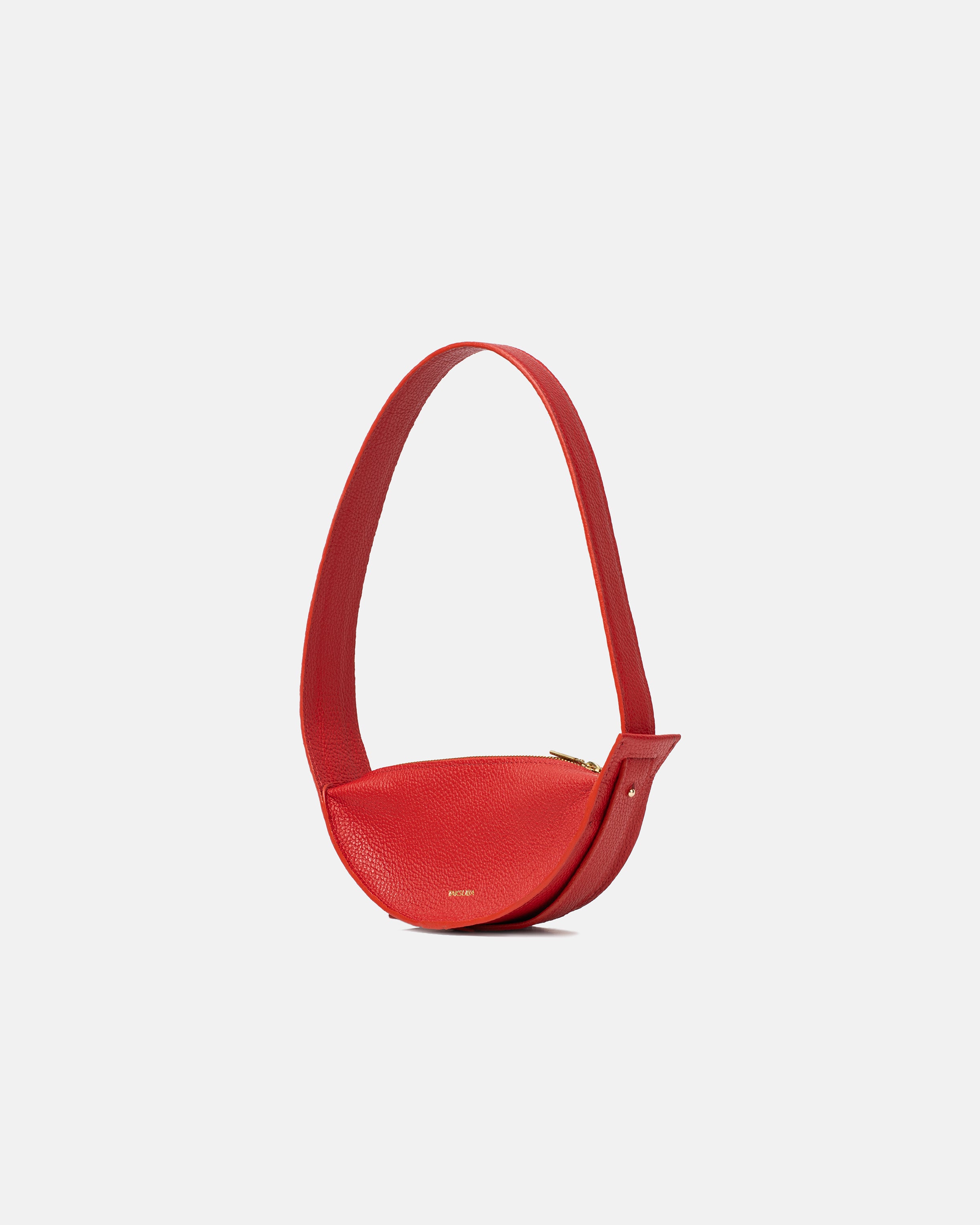 Modna czerwona skórzana torebka na ramię Eclipse z zaokrąglonym kształtem i delikatnymi detalami.