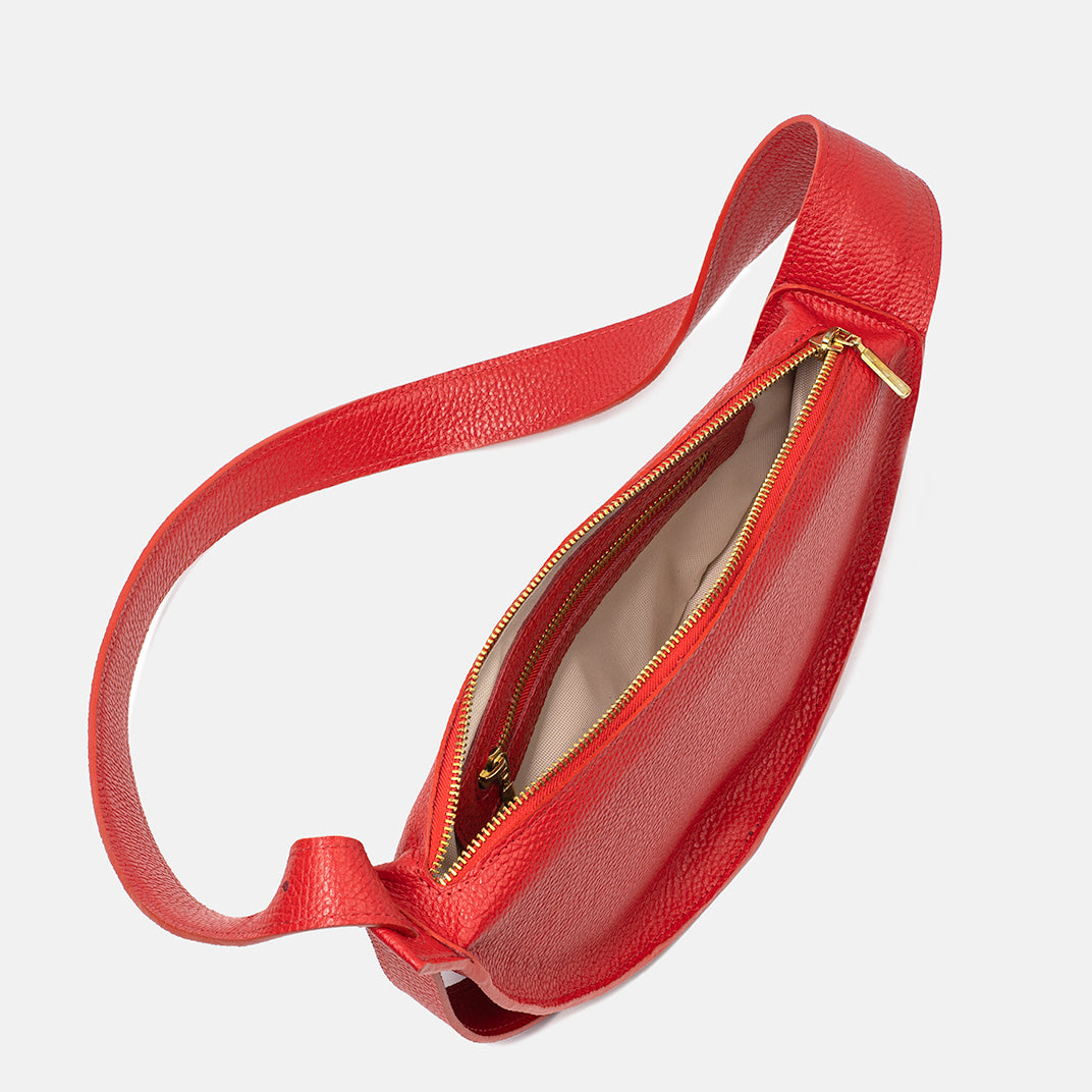 Interior of the red Eclipse M leather handbag with beige lining and gold-tone zipper