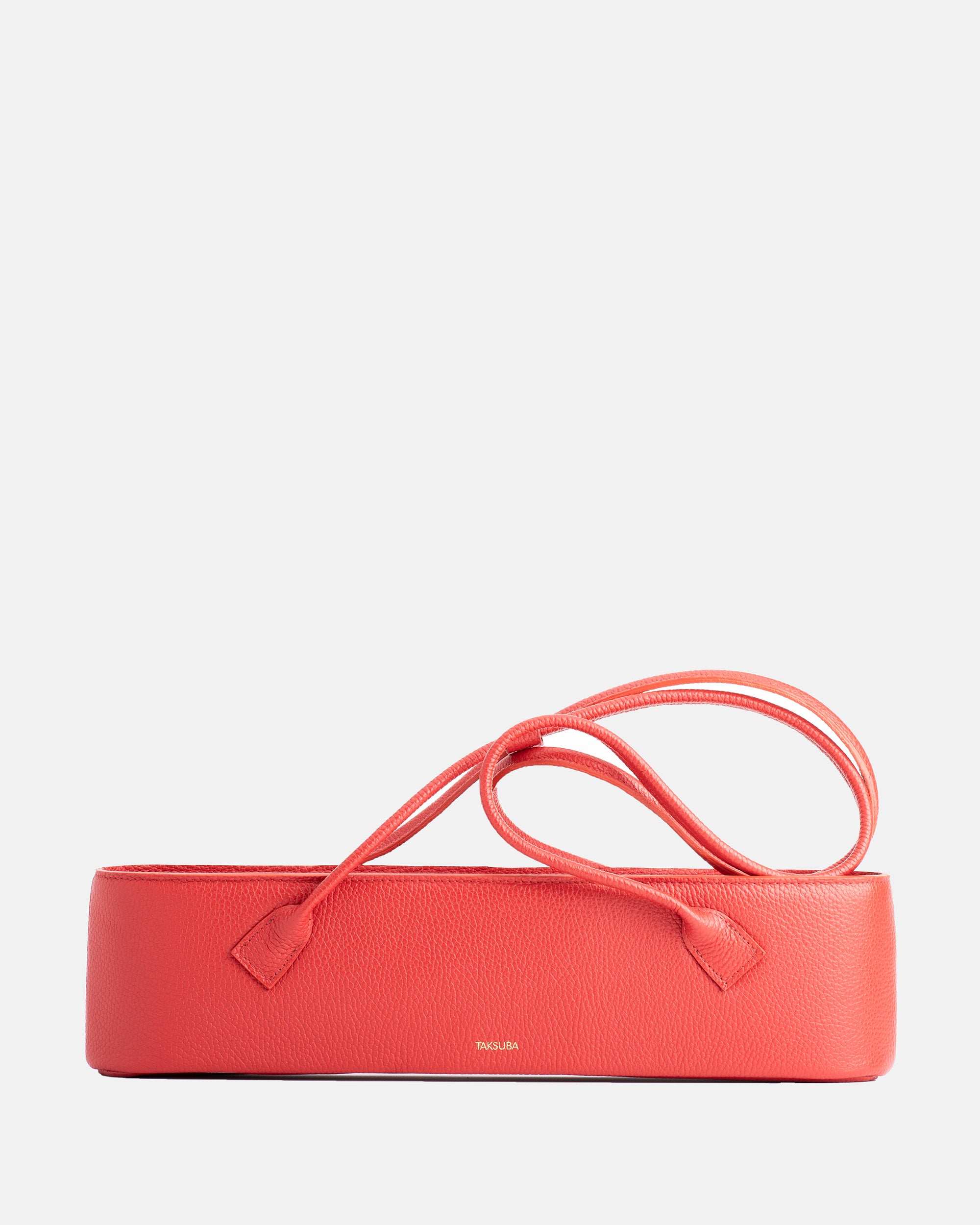 Red Teckelete leather handbag in an outdoor lifestyle setting