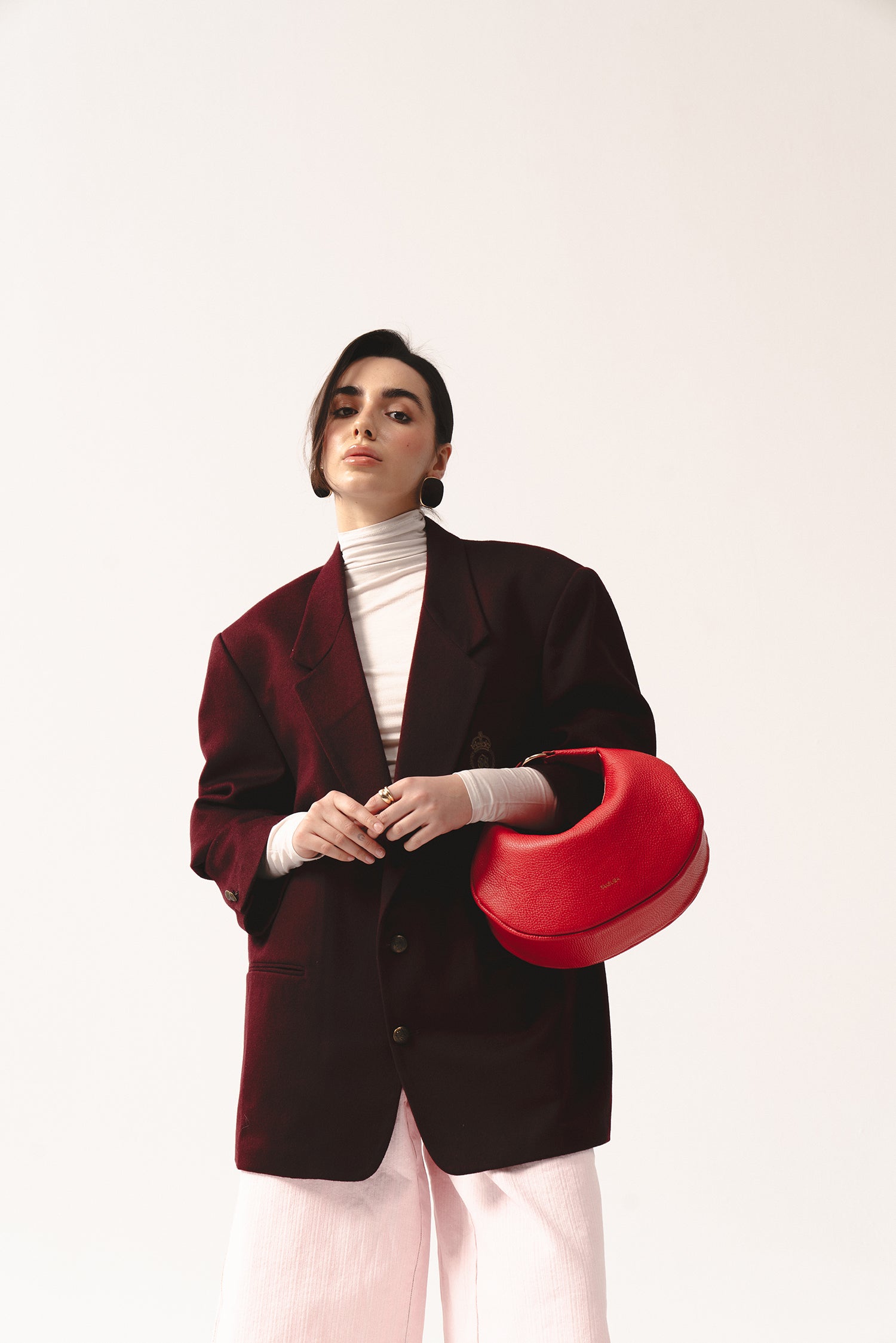 Skórzana torebka Hedera czerwona na ramię, elegancki look z bordową marynarką i białym golfem