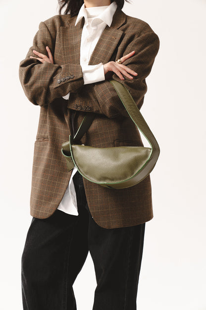 Skórzana torebka półksiężycowa oliwkowa na ramię – crescent-shaped leather shoulder bag in olive green worn crossbody style