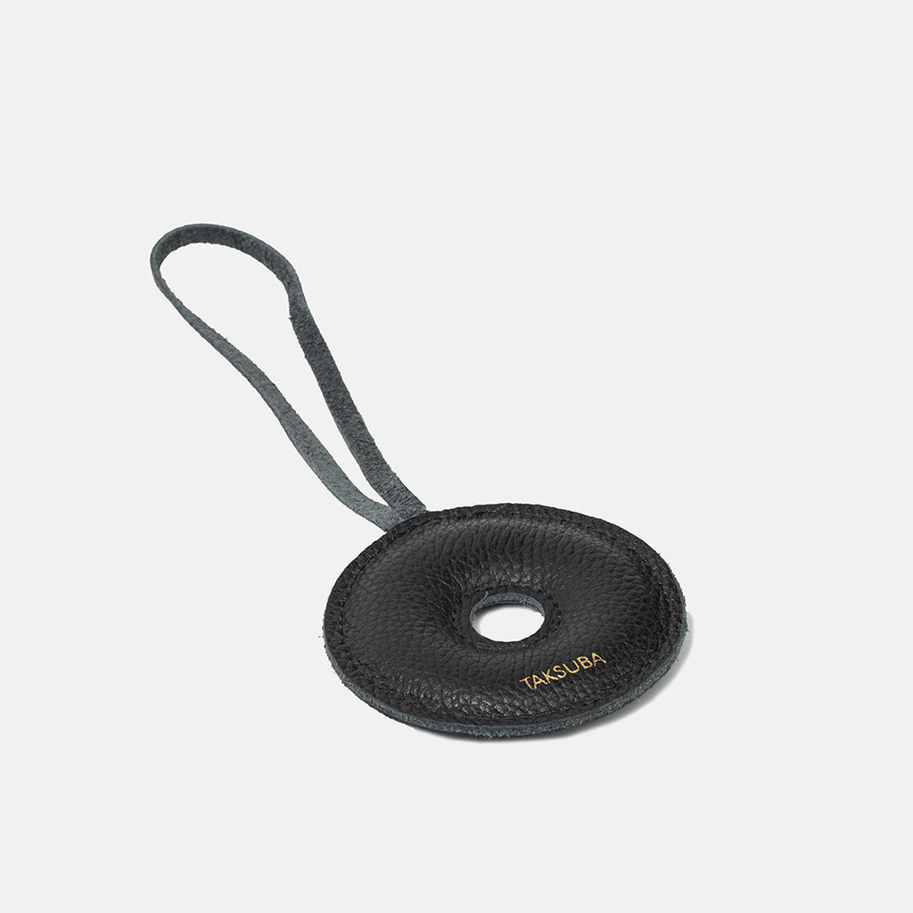 Skórzana zawieszka Donut TAKSUBA – czarna, minimalistyczna z logo, widok produktu z pętelką