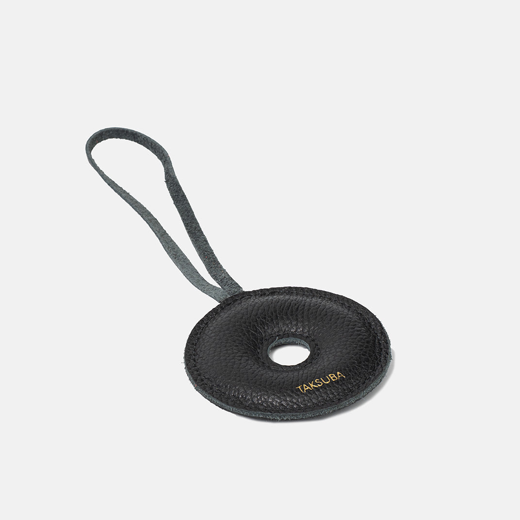 Skórzana zawieszka Donut TAKSUBA – czarna, minimalistyczna z logo, widok produktu z pętelką