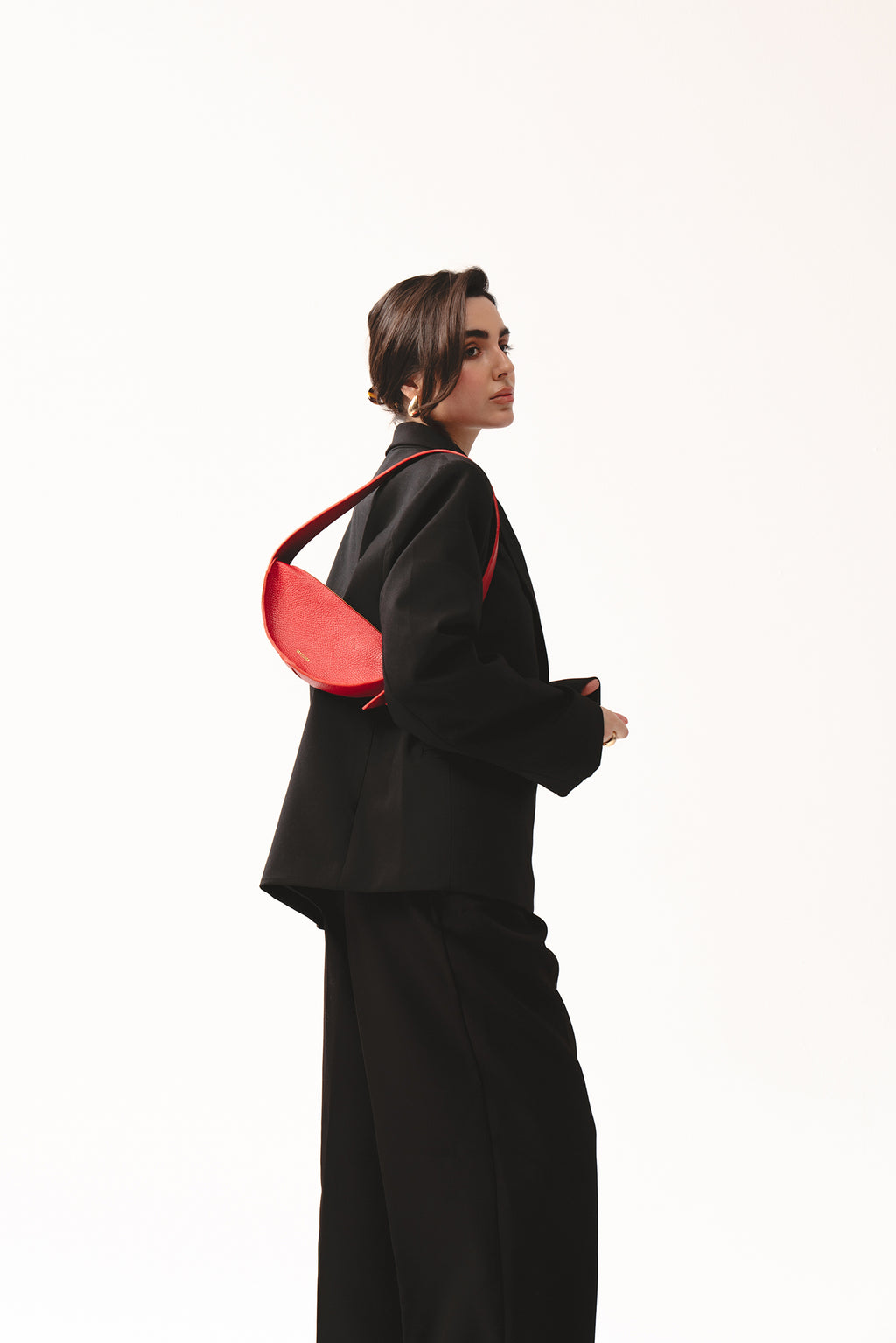 Skórzana torebka damska czerwona na ramię – półokrągła torba Eclipse S z fakturowanej skóry, noszona na ramieniu w eleganckiej stylizacji total black.
