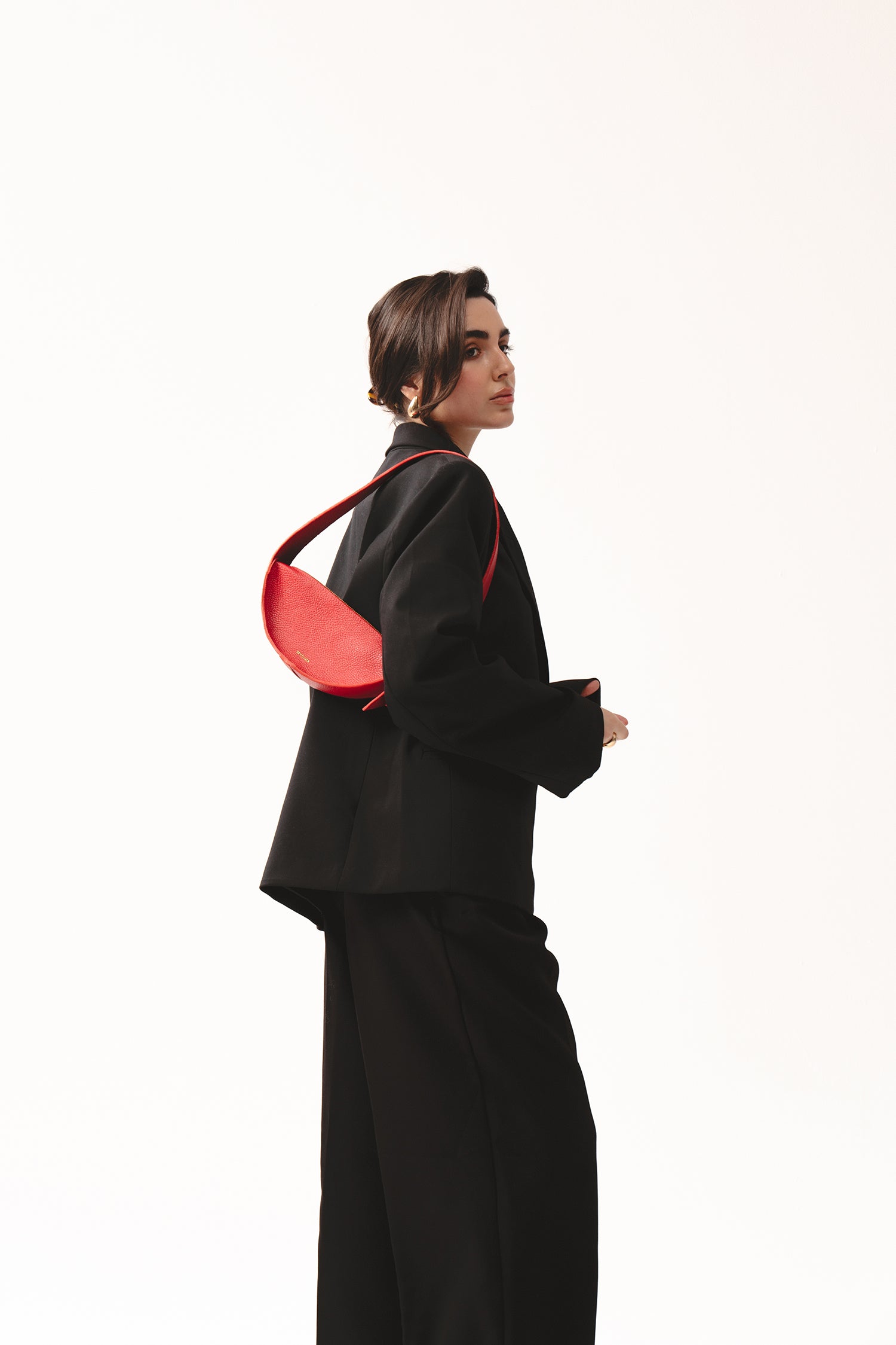 Skórzana torebka damska czerwona na ramię – półokrągła torba Eclipse S z fakturowanej skóry, noszona na ramieniu w eleganckiej stylizacji total black.