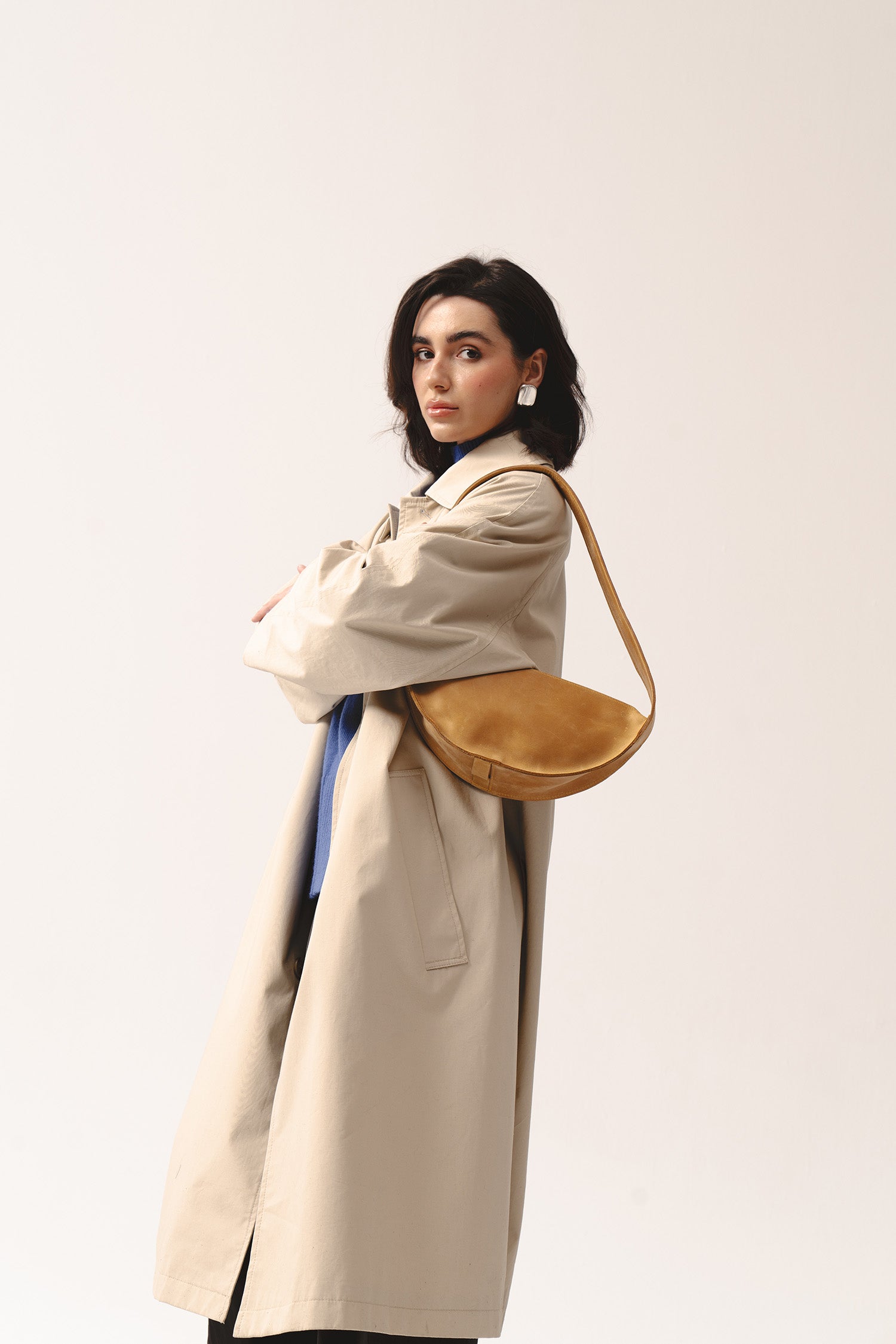 Torebka Eclipse M żółta skórzana na ramieniu kobiety w jasnym trenczu