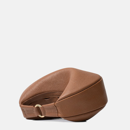 Brązowa skórzana torebka Hedera TAKSUBA leżąca na boku, detal dolnej części i paska