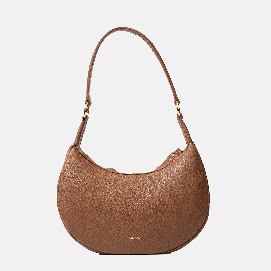 Brązowa skórzana torebka Hedera TAKSUBA z długim paskiem na ramię, widok z przodu na jasnym tle