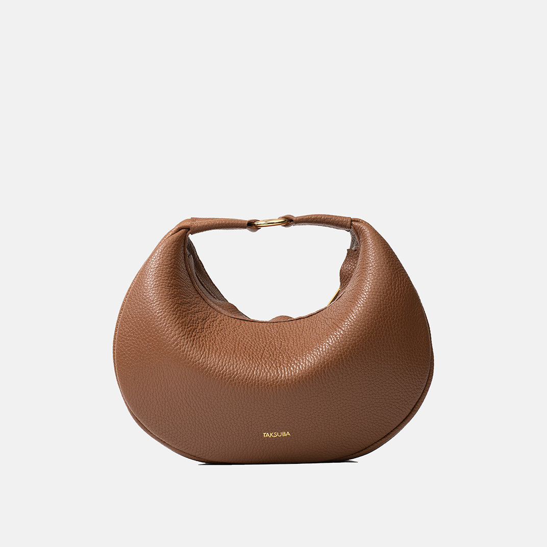 Brązowa skórzana torebka Hedera TAKSUBA na złotym zapięciu, widok z przodu na jasnym tle