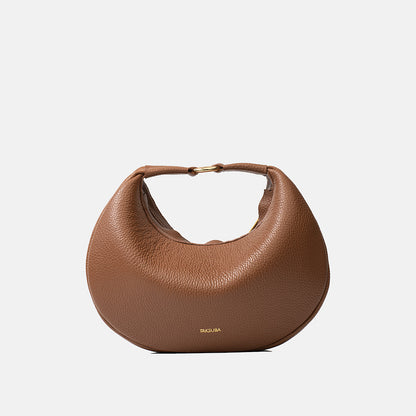 Brązowa skórzana torebka Hedera TAKSUBA na złotym zapięciu, widok z przodu na jasnym tle