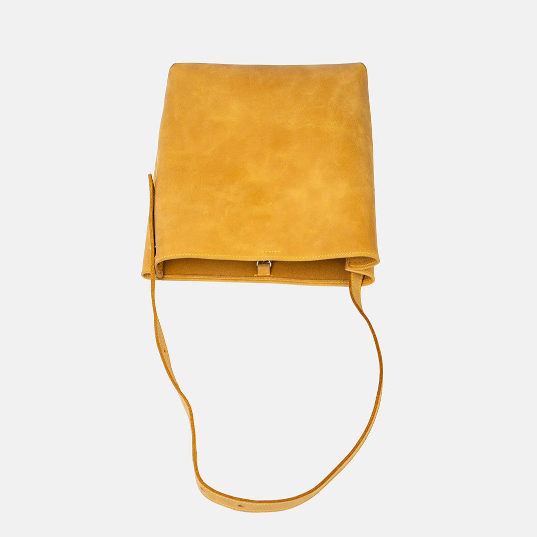 Żółta skórzana torebka shopper z regulowanym paskiem i zapięciem na karabinek marki Taksuba