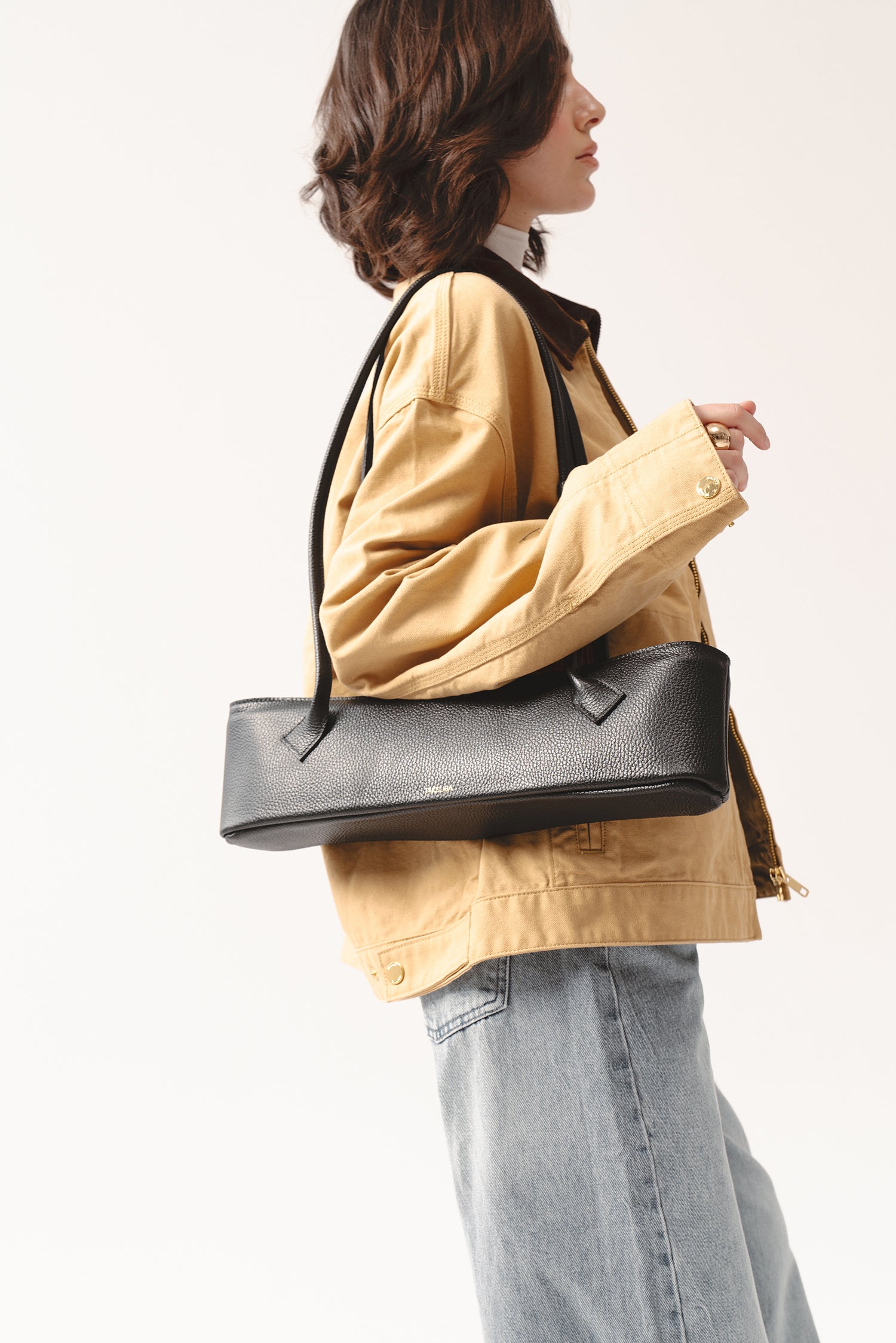 Skórzana czarna torebka Teckelete na ramię w casualowej stylizacji z kurtką i dżinsami